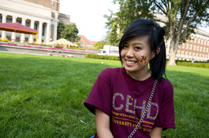 Student posing on grass in mall area on campus