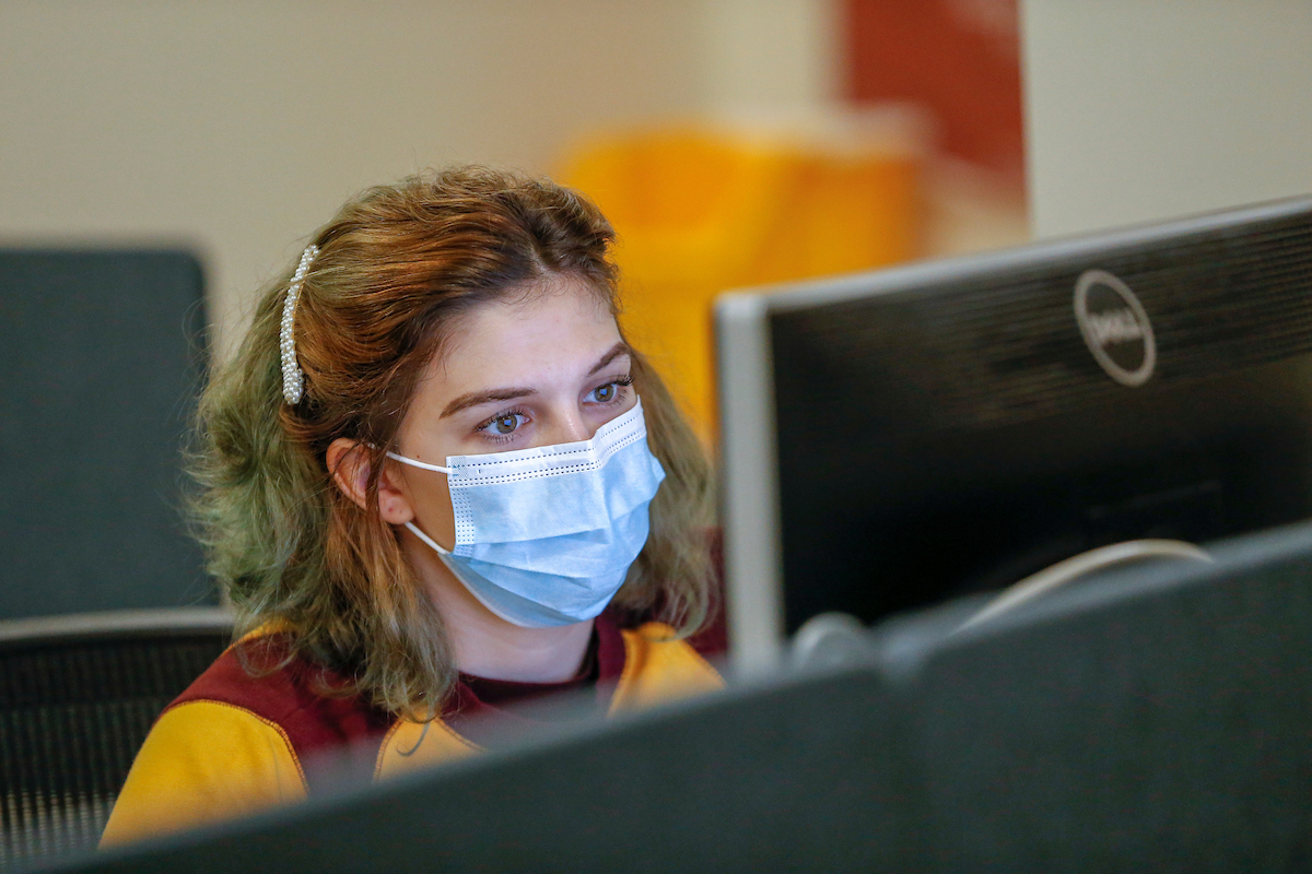 student with face mask on computer
