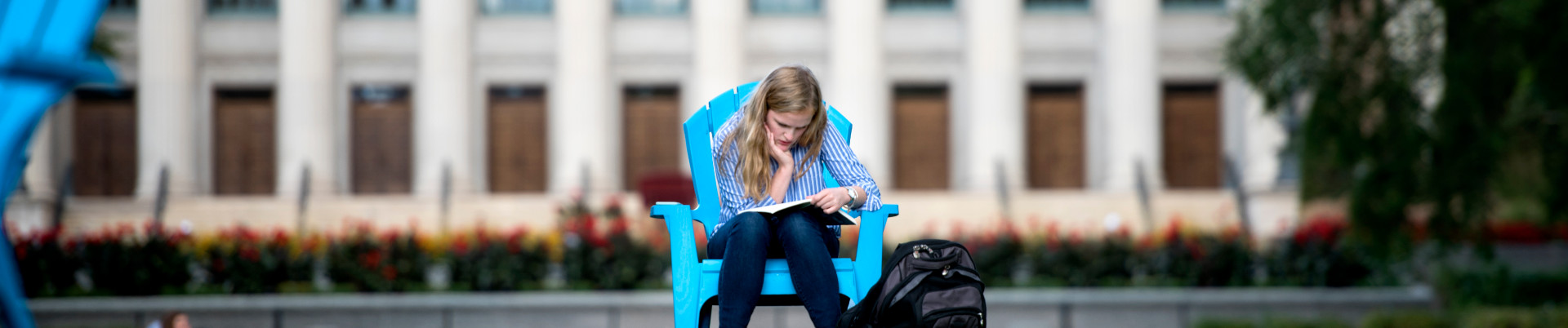 A student sits on the mall lawn and studies
