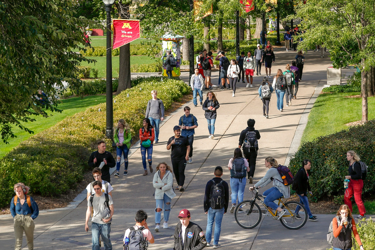 Students walk and bike on the sidewalks of the mall
